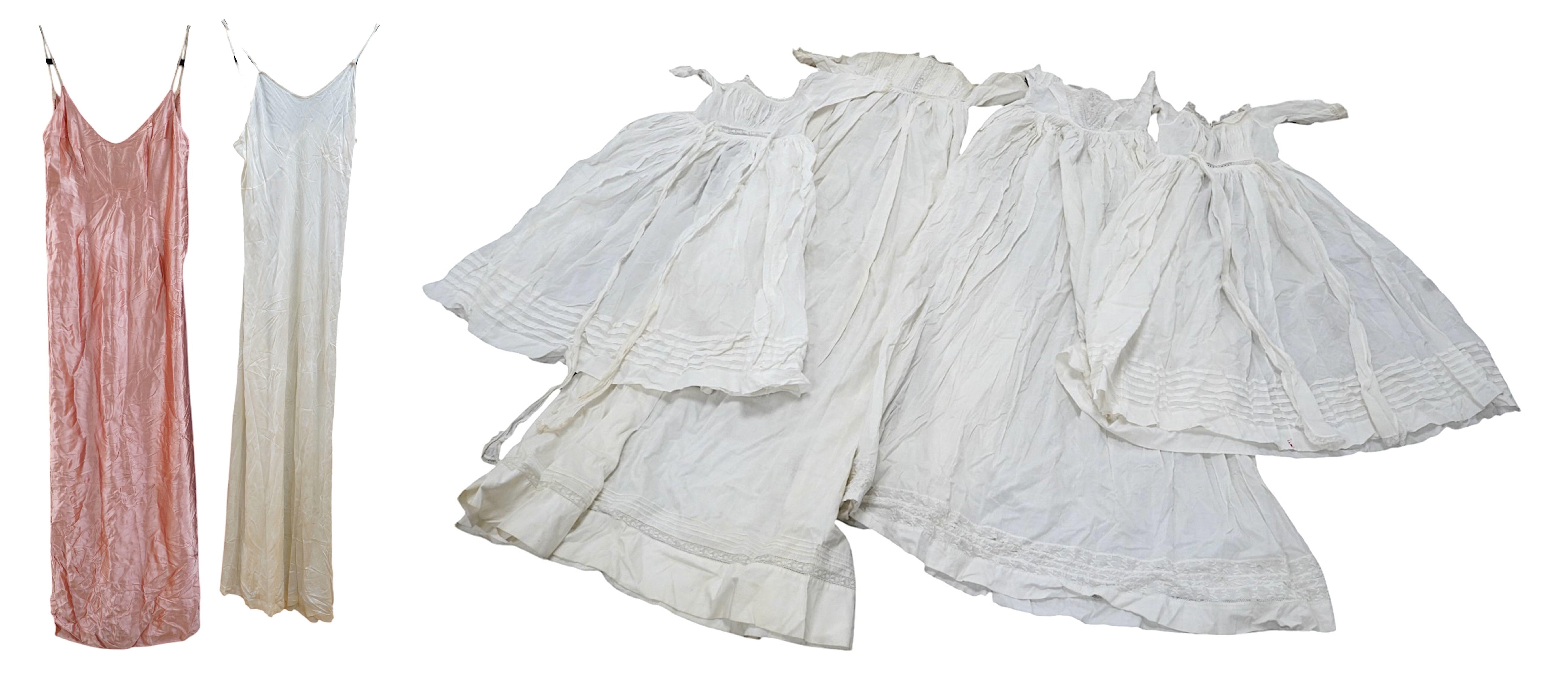 Two late 19th early 20th century long baby night gowns and two shorter baby gowns, together with a pink satin ladies full length slip and a similar cream silk stockinette slip, the bodices worked on baby dresses are embr